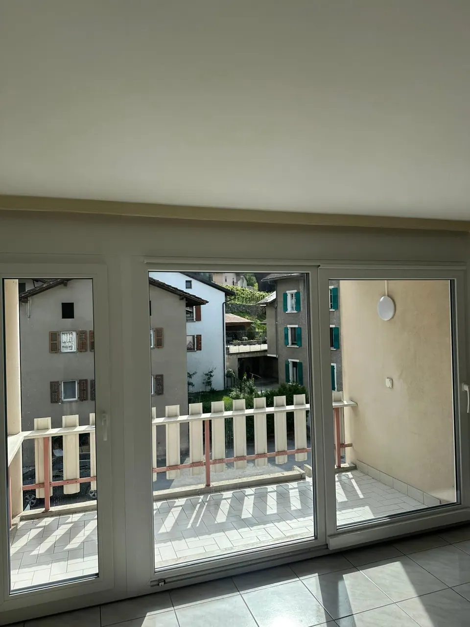 Baie vitrée en PVC blanc ouvrant sur un balcon