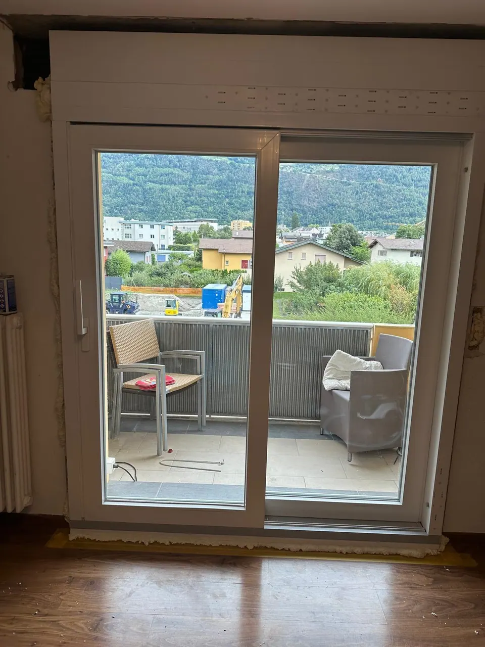 Porte-fenêtre coulissante en PVC blanc donnant sur un balcon